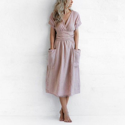 Woman wearing a pink dress with pockets against a white background
