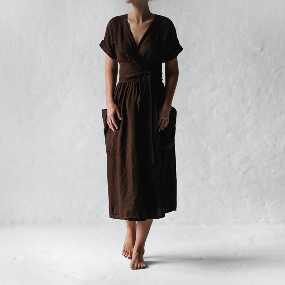 Person wearing a brown dress against a white background