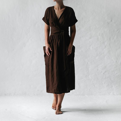 Person wearing a brown dress against a white background