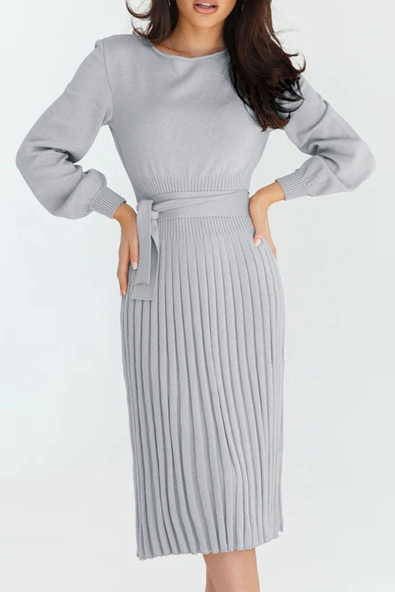 Woman wearing a gray ribbed dress with a belt on a white background