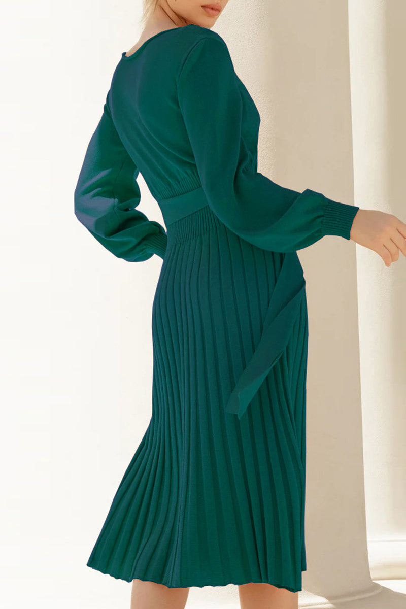 Green pleated dress worn by a person in a bright setting