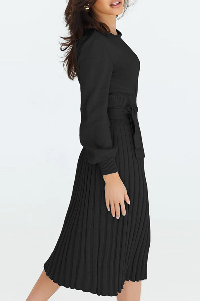 Woman wearing a black pleated dress on a white background