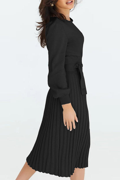 Woman wearing a black pleated dress on a white background