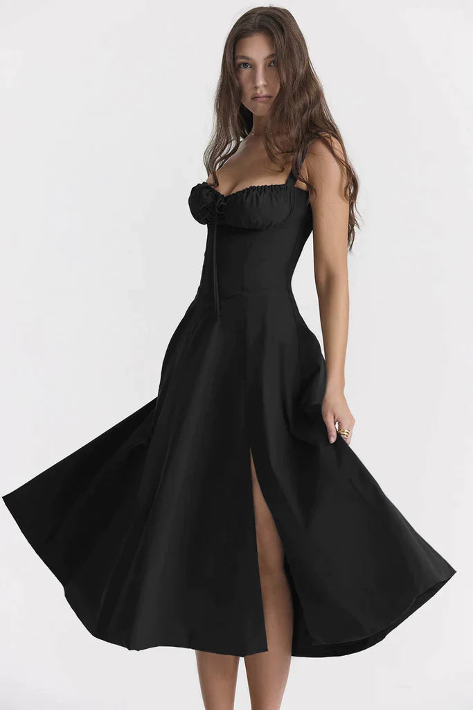 Black dress with a high slit worn by a model on a white background