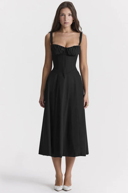 Woman wearing a black dress with ruffled top on a white background