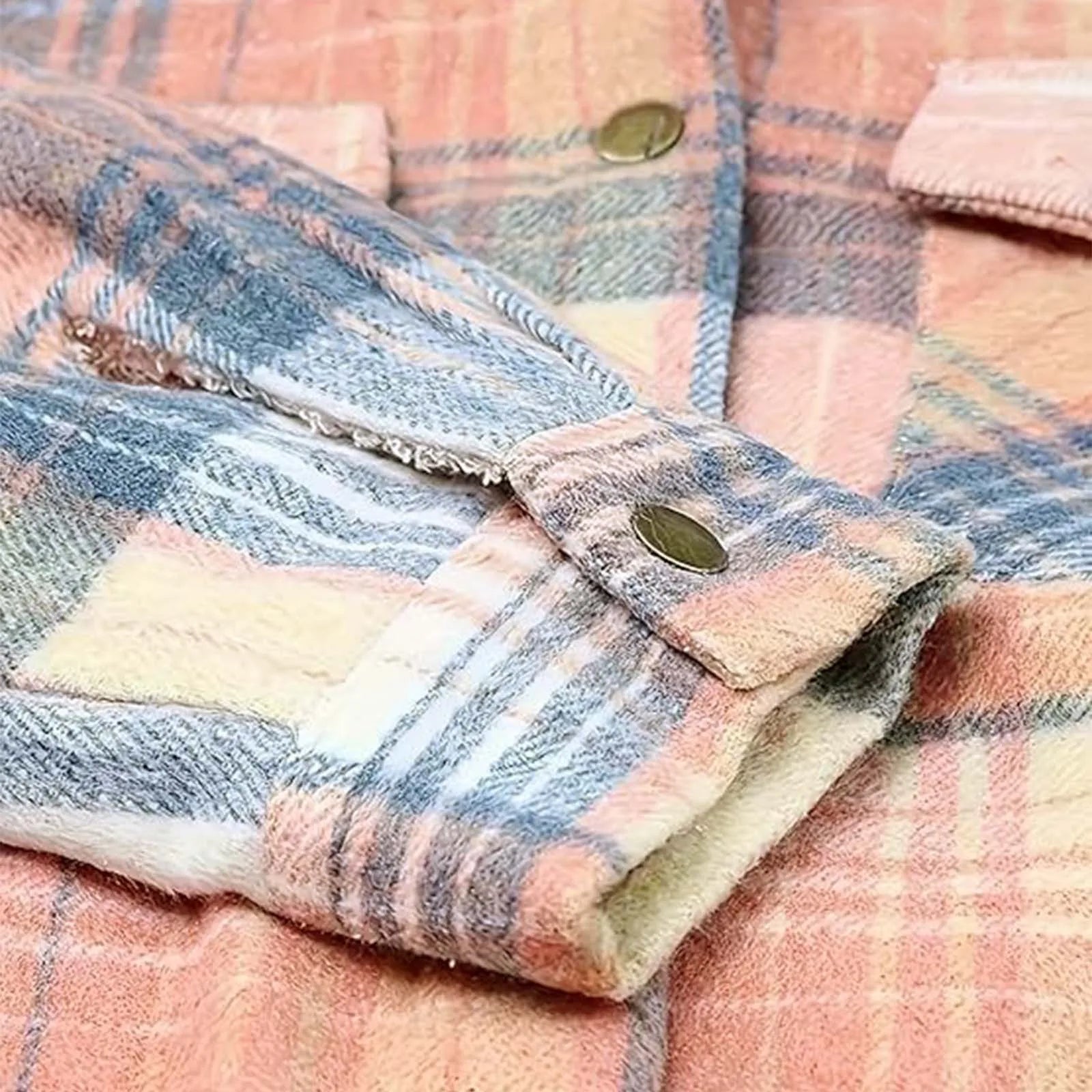 Close-up of a plaid fabric with pink, blue, and white colors.