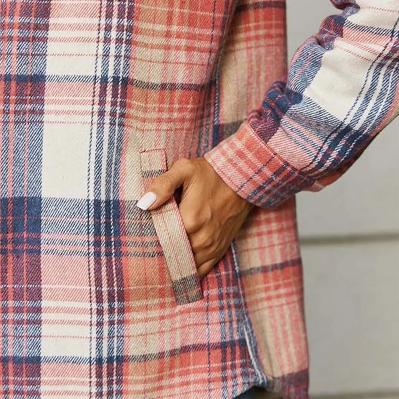 Close-up of a person wearing a plaid shirt with a neutral background