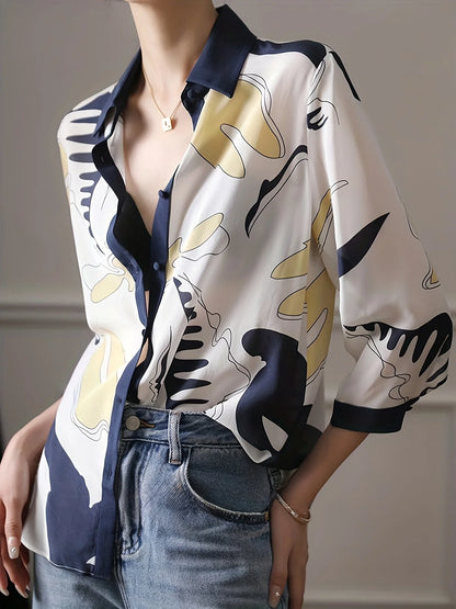 Person wearing a patterned shirt with abstract designs in white, black, and yellow, paired with blue jeans.